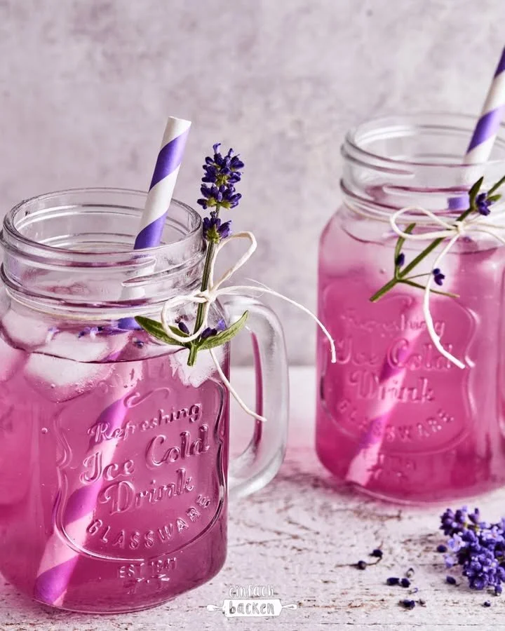 Glas mit erfrischender Lavendel-Limonade auf einem Holz Tisch.