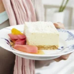 Limetten-Frischkäse-Torte auf einem Teller serviert, dekoriert mit frischen Limetten.