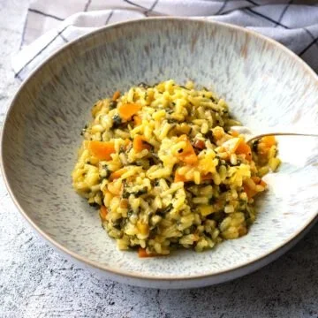 Leckeres Mangoldrisotto auf einem Teller, mit frischem Mangold und Parmesan garniert.