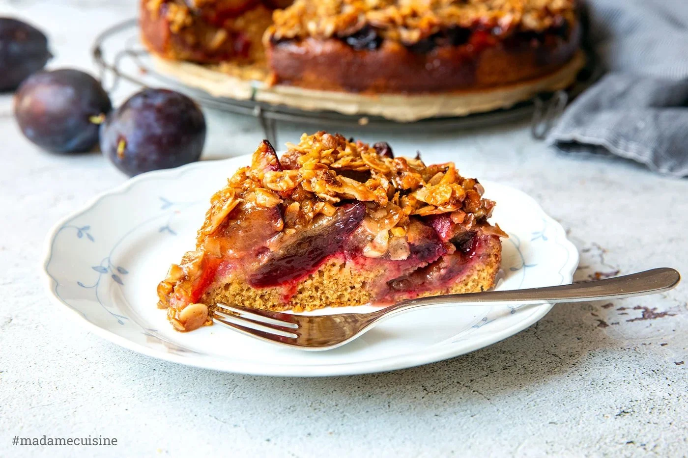Pflaumenkuchen mit Mandelkruste auf einem Teller serviert