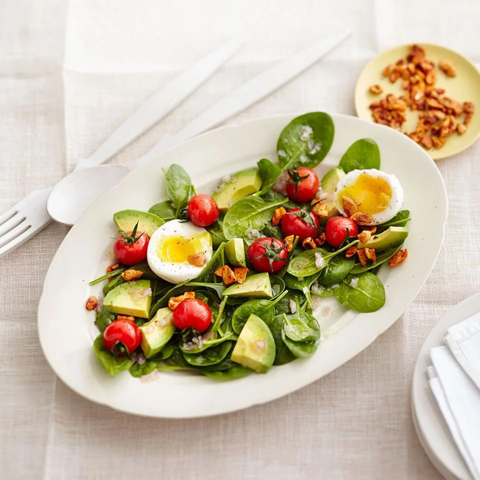Spinat-Salat mit Avocado und Ei auf einem Teller