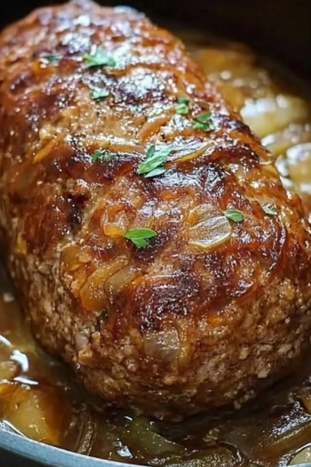 Saftiger Zwiebel-Hackbraten frisch aus dem Ofen, angerichtet auf einem Teller