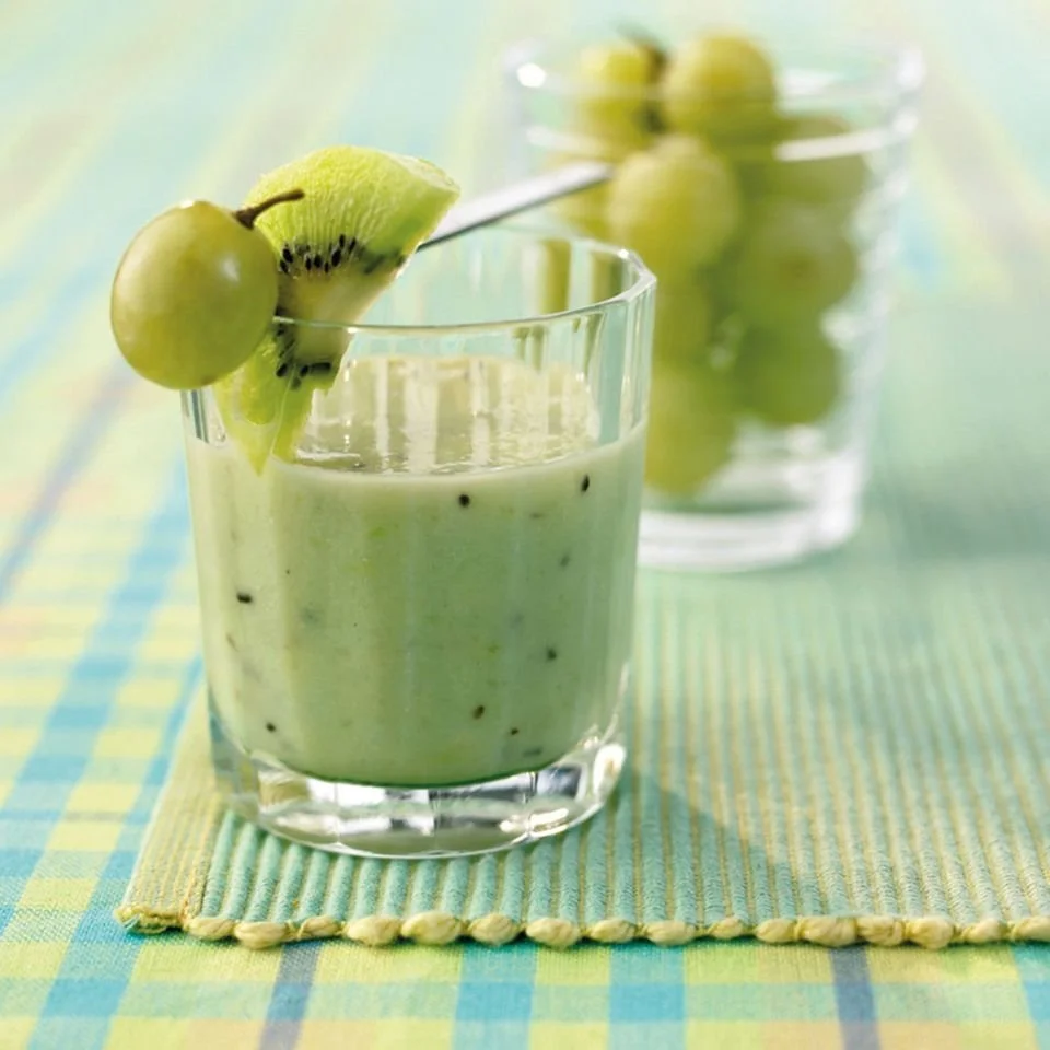 Frischer Trauben Kiwi Smoothie in einem Glas auf einem Holztisch