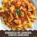 Bandnudeln mit Hähnchen und Tomatensahnesauce auf einem Teller