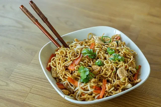 Schüssel mit chinesischen gebratenen Nudeln, Huhn, Ei und Gemüse