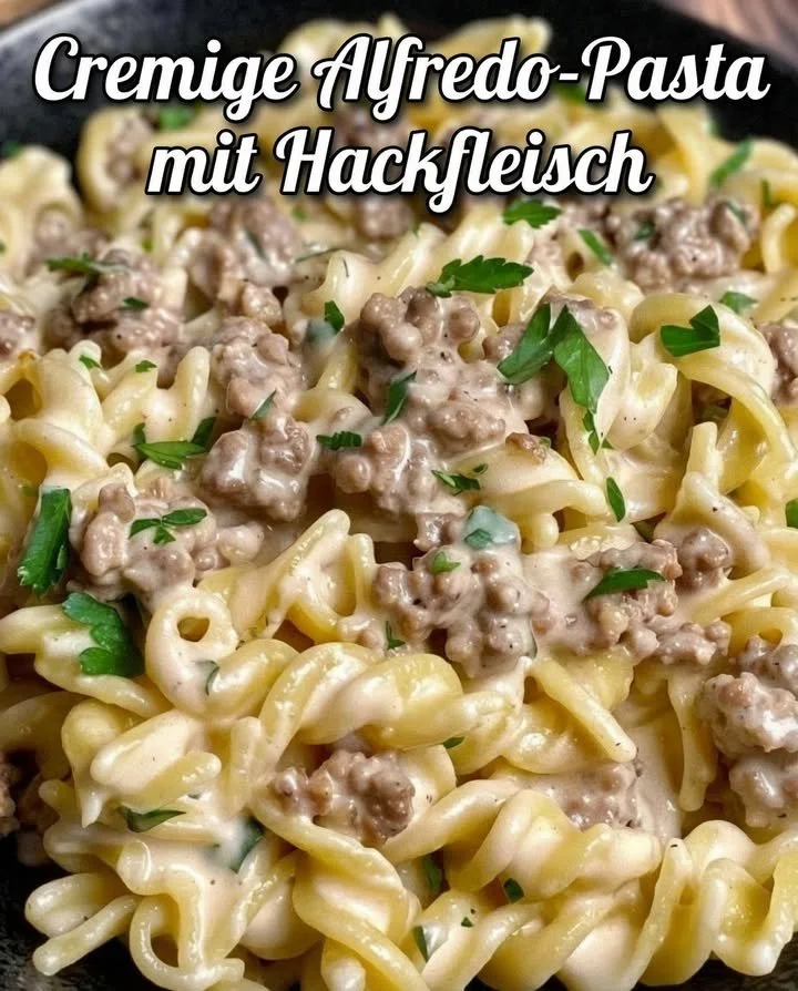 Cremige Pasta mit Sauce auf einem Teller, garniert mit frischen Kräutern.