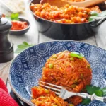 Djuvec Reis nach Originalrezept auf einem bunten Teller serviert