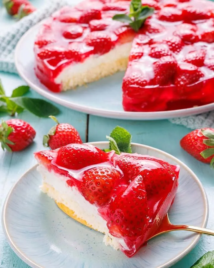 Leckerer Erdbeerkuchen mit Pudding auf einem Teller, garniert mit frischen Erdbeeren.