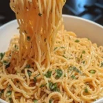 Ein Teller mit Knoblauch Spaghetti, garniert mit frischen Kräutern.