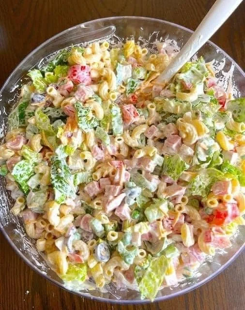 Nudelsalat mit Joghurt auf einem Teller, garniert mit frischen Kräutern