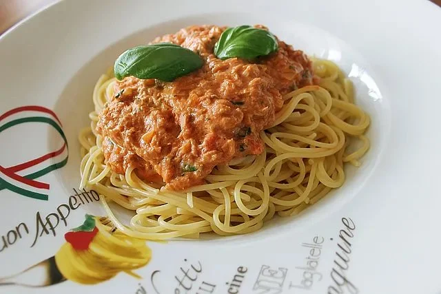 Pasta mit Thunfisch-Tomaten-Käse-Sauce auf einem Teller serviert
