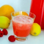 Erfrischende pinke Limonade in einem Glas mit Zitrone und Strohhalm