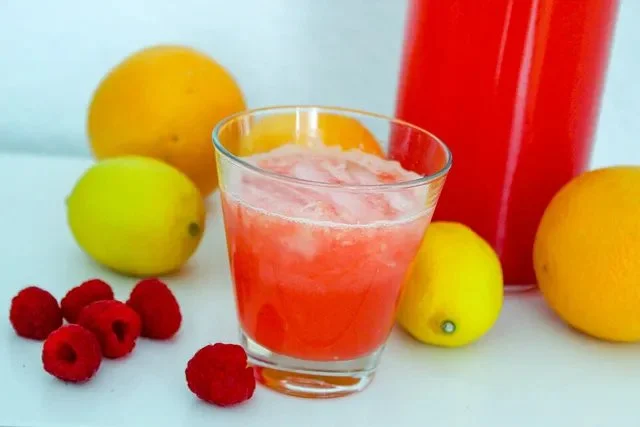 Erfrischende pinke Limonade in einem Glas mit Zitrone und Strohhalm