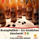 Flasche Bratapfellikör mit Zimt und Äpfeln auf einem Holztablett