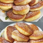 Leckere Quarkpfannkuchen auf einem Teller mit frischen Früchten und Puderzucker