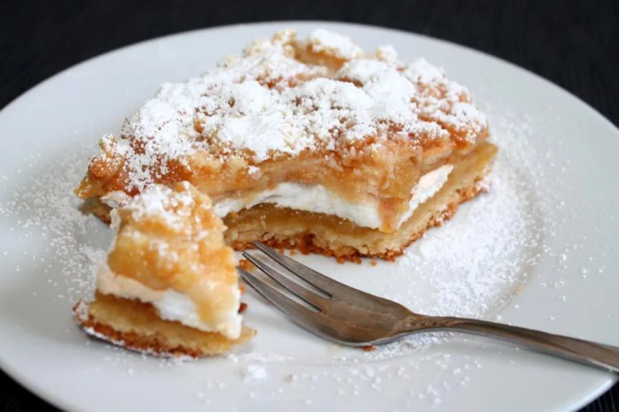 Apfelkuchen mit Baiser und Streusel auf einem Teller serviert