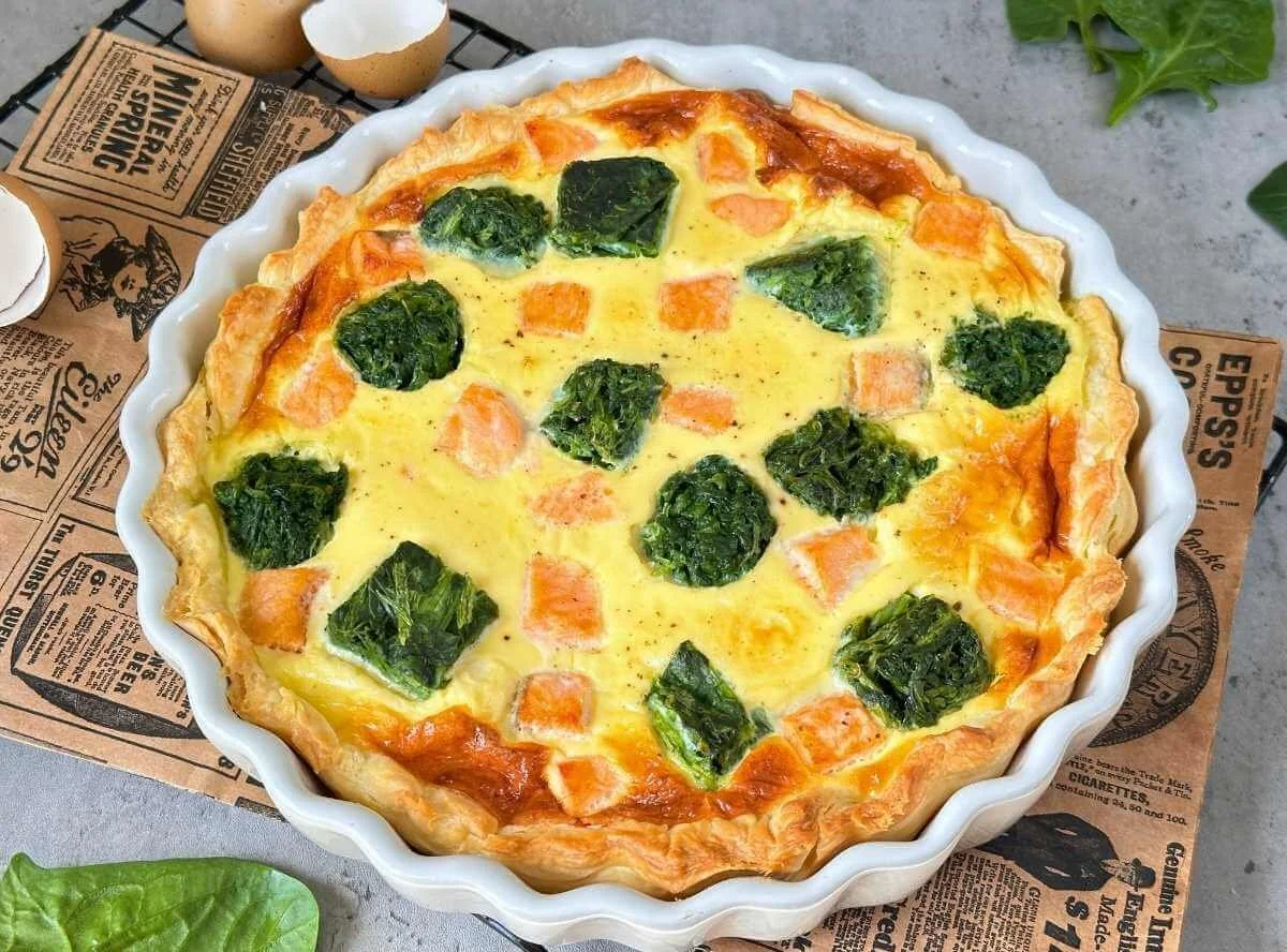 Blätterteig Quiche mit Spinat und Lachs auf einem Teller angerichtet