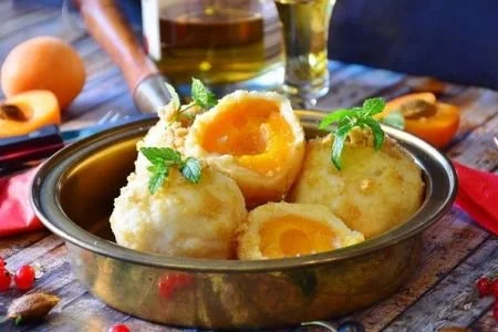 Flaumige Marillenknödel mit Aprikosen in einem traditionellen österreichischen Dessert.