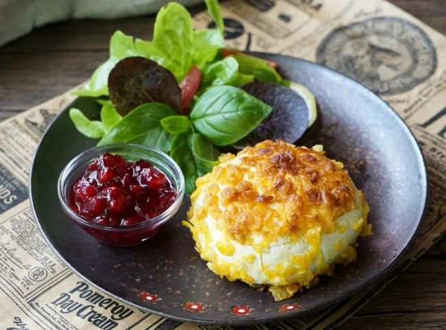 Selbst gemachter gebackener Camembert mit frischem Baguette und Kräutern