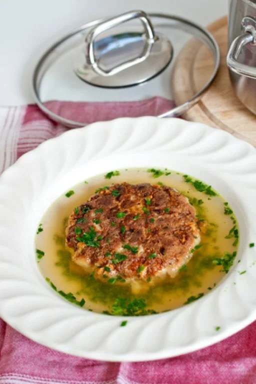 Traditionelle Kaspressknödelsuppe in einer Schüssel serviert