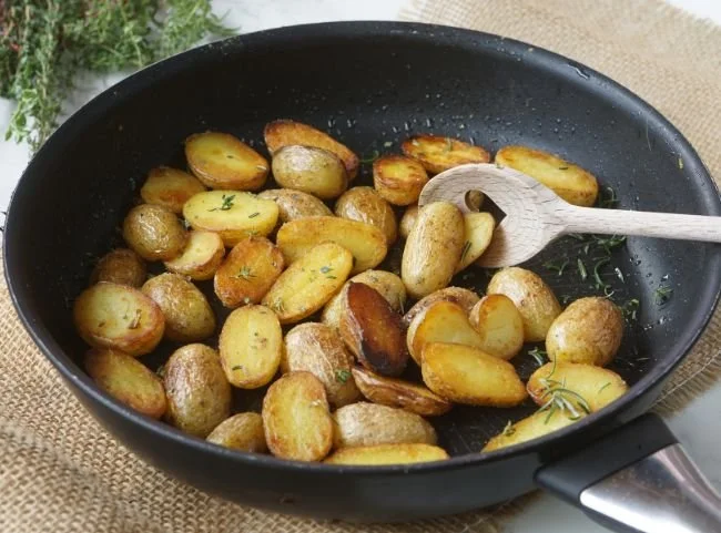 Kleine Kartoffeln in der Pfanne zubereitet mit frischen Kräutern