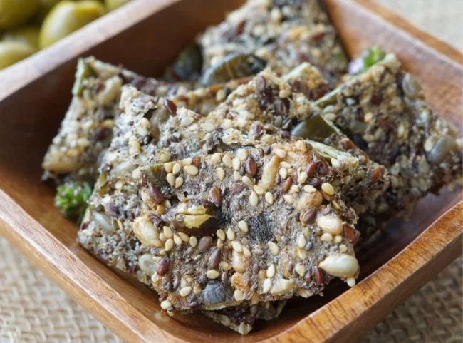 Gesunde Low Carb Cracker auf einem Holzbrett präsentiert