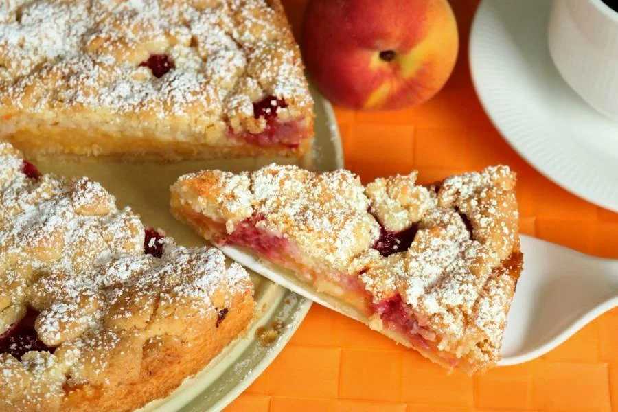 Pfirsich-Melba-Streuselkuchen mit knusprigem Streuselbelag und frischen Pfirsichen.